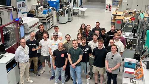 Eine Gruppe von Technikern steht im Spritzgusstechnikum im SKZ