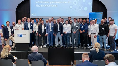 Gruppenfoto auf einer Bühne vor einer Leinwand