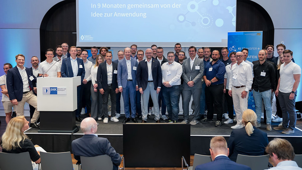 Gruppenfoto auf einer Bühne vor einer Leinwand